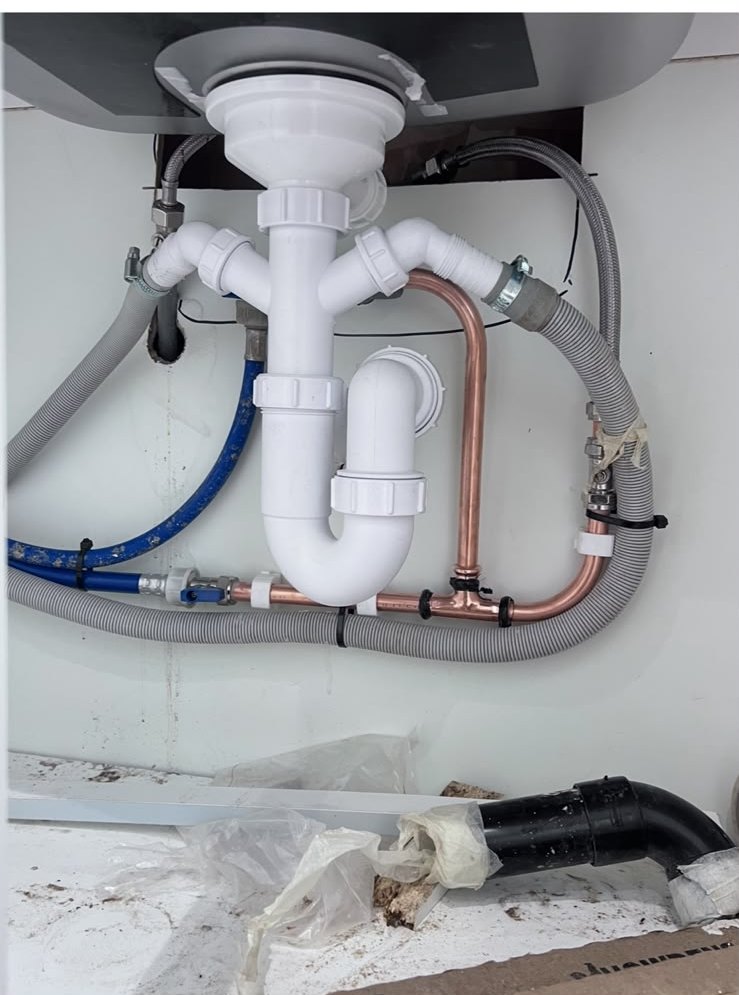 Neatly installed sink waste and copper supply pipework