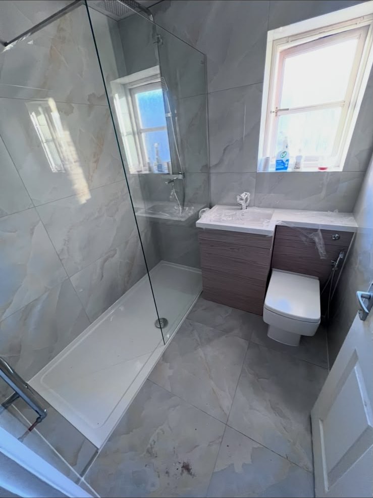 Marble-effect bathroom with frameless walk-in shower and vanity unit